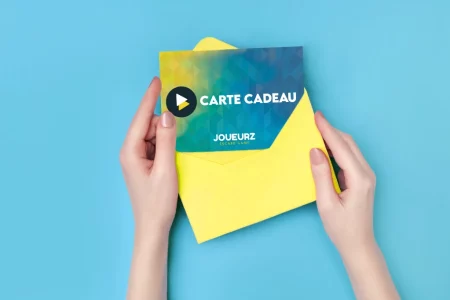 Illustration carte cadeau Joueurz Une enveloppe jaune dans des mains sur un fond bleu ciel. L'enveloppe est ouverte et contient une carte cadeau Joueurz